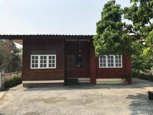 uma pequena casa vermelha com janelas brancas em บ้านสุขใจ (Ban Suk Jai) 