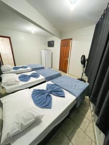 two beds in a room with a refrigerator at Hotel Brasil Anapolis Goias in Anápolis