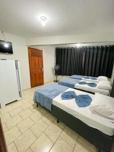 a bedroom with two beds and a tv at Hotel Brasil Anapolis Goias in Anápolis