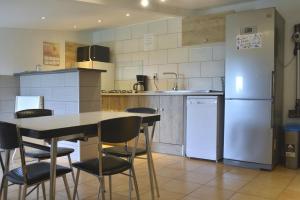 La cuisine est équipée d'une table, de chaises et d'un réfrigérateur. dans l'établissement Gîte Kerlosvézan, à la campagne, proche mer, à Lampaul-Ploudalmézeau