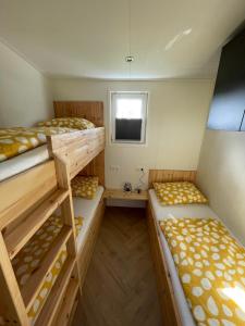 Chalet 't Kwedammertje في Kwadendamme: سريرين بطابقين في غرفة صغيرة مع نافذة