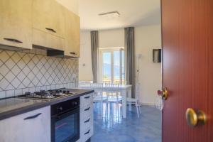 a kitchen with a stove and a table with chairs at L'Incanto del Golfo li cylentos in Scario