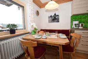 uma sala de jantar com uma mesa de madeira e cadeiras em Gästehaus Koch em Fischen