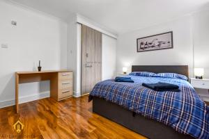 a bedroom with a bed and a wooden desk at Charming River View 3 bedroom Apartment in the Heart of London in London