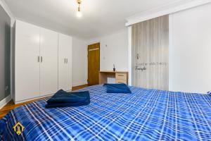 a bedroom with a bed with blue pillows on it at Charming River View 3 bedroom Apartment in the Heart of London in London