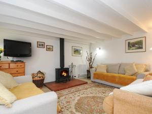 a living room with a couch and a fire place at Henwood Barn in Liskeard