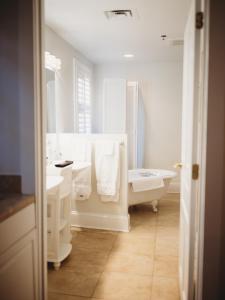 a white bathroom with a tub and a sink and a toilet at The Jefferson Inn in Southern Pines