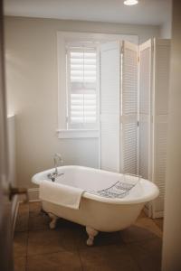 eine weiße Badewanne im Bad mit Fenster in der Unterkunft The Jefferson Inn in Southern Pines