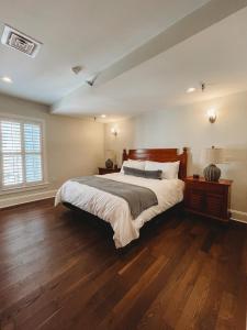 ein Schlafzimmer mit einem großen Bett und Holzböden in der Unterkunft The Jefferson Inn in Southern Pines