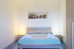een slaapkamer met een bed met 2 kussens erop bij L'Incanto del Golfo in Scario
