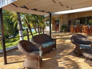 a patio with wicker chairs and an umbrella at Enseada Náutico Apart Flat Quinto Andar in Caldas Novas