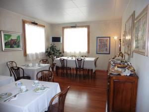 a dining room with tables and chairs with white tablecloths at A Casa Di Paola in Chiarano