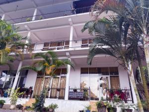 a building with palm trees in front of it at Holiday Homes Guest Inn - Ella in Ella