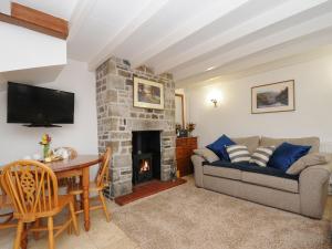 a living room with a couch and a fireplace at Small Barn in Liskeard