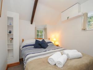 a bedroom with a bed with towels on it at Small Barn in Liskeard