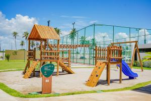 a park with a playground with a slide and swings at Mana Beach Experience By Mai in Porto De Galinhas