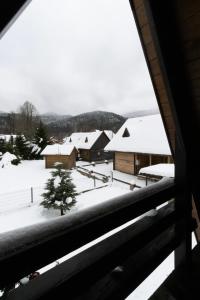a view from a window of a snow covered village at Alpska kuća Klek in Jasenak