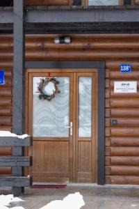 a front door of a building with a wreath on it at Alpska kuća Klek in Jasenak