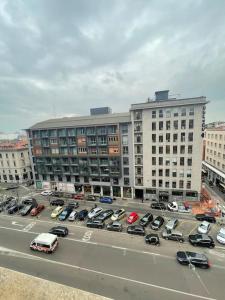 米蘭的住宿－NEW LUXURY STUNNING BILO APARTMENT IN THE HEART OF MILAN MOSCOVA，大型建筑前的停车场,有车辆停放