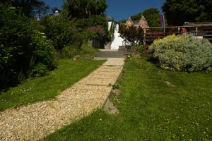 a path in a garden with grass and bushes at Epchris House in Ilfracombe
