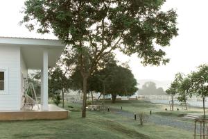 a white house with a tree and a playground at Stayokay Sattahip - Flat House in Sattahip +4 photos