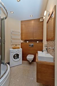 y baño con lavadora y lavamanos. en Apartament Yellow Taxi, en Karwia