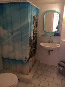 uma casa de banho com um lavatório, um WC e um espelho. em Hotel Pension Streuhof Berlin em Berlim