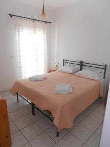 a bedroom with a large bed with an orange blanket at Glaros Rooms in Koufonisia