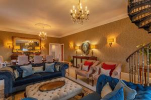 a large living room with blue couches and chairs at Glenapp Castle in Ballantrae