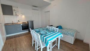 a room with a table with chairs and a kitchen at Ricomincio da Polignano in Polignano a Mare