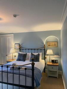 um quarto com uma cama com paredes azuis e 2 candeeiros em Saplinbrae Hotel and Lodges em Mintlaw