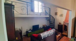 a living room with a couch and a spiral staircase at Villino Chianti in Cavriglia