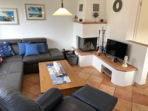 a living room with a couch and a fireplace at Mine Heimat _ Dat Roeverhus_ in Zingst