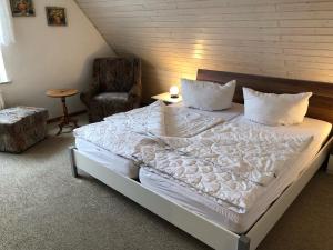 a bedroom with a large white bed and a chair at Nehmzowsgang 13 in Zingst