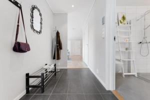 a hallway with white walls and a staircase with a bench at Stor og moderne leilighet i Indre Arna Bergen GRATIS PARKERING!! in Bergen