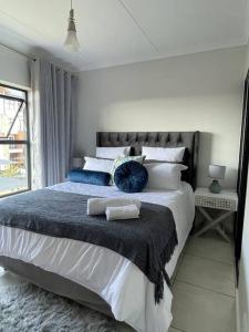 a bedroom with a large bed with blue pillows at Home away from home in Avondzon