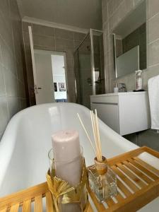 a candle on a tray next to a bath tub at Home away from home in Avondzon