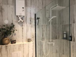 a shower with a glass door in a bathroom at Czuła Chata Ojców in Prądnik Czajowski