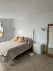 a bedroom with a bed and a white wall at Chalet Jamaica 2 in Peniscola +16 photos