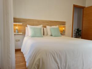 a bedroom with a large white bed with blue pillows at Glory Home II Catedral in Zamora