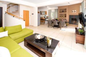 普羅塔拉斯的住宿－Villa Emily，客厅配有绿色沙发和桌子