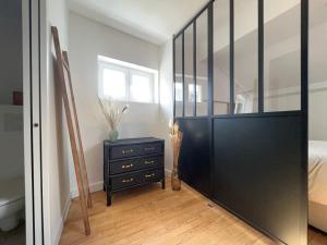 sypialnia z czarną komodą i lustrem w obiekcie Superbe studio plein de charme proche du centre Tonnet w mieście Clermont-Ferrand