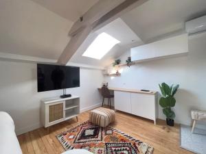 salon z telewizorem z płaskim ekranem na ścianie w obiekcie Superbe studio plein de charme proche du centre Tonnet w mieście Clermont-Ferrand
