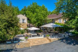 an aerial view of a house with tables and umbrellas at Camping le Clou in Coux-et-Bigaroque