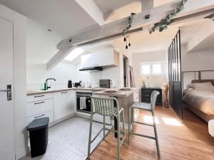 kuchnia ze stołem, krzesłami i łóżkiem w obiekcie Superbe studio plein de charme proche du centre Tonnet w mieście Clermont-Ferrand +4 zdjęcia