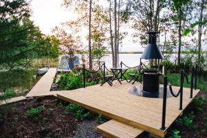 a wooden dock with a picnic table and a lamp at AuroraHut Aurantola in Kouvola