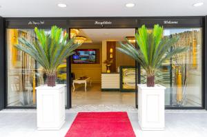 two palm trees in white vases in front of a store at Alya Boutique Hotel in Trabzon