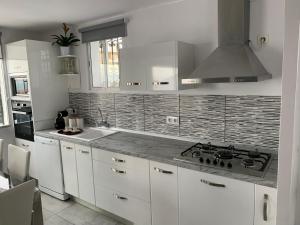 a kitchen with white cabinets and a stove top oven at Chalet Jamaica 2 in Peniscola
