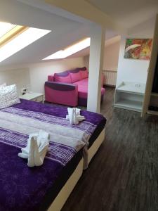 um quarto com 2 camas e um sofá rosa em Red House em Kyustendil