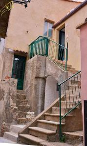 un escalier menant à un bâtiment avec balcon. dans l'établissement alcastello - casa campanile, à Isola del Giglio
